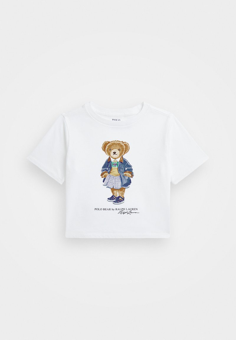 White short-sleeve T-shirt featuring an illustrated bear wearing a denim jacket and plaid skirt. Cotton fabric with a crew neck design.