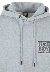 Felpa grigia realizzata in tessuto morbido, con una tasca frontale, cordini regolabili e una toppa nera con la scritta "HOME BOY loud-couture".