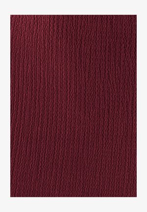 Bordowy teksturowany materiał z falistym wzorem, o miękkiej i lekko pofałdowanej powierzchni, idealny na tapicerkę lub ubrania.