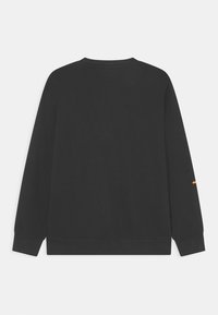 Felpa nera con maniche lunghe, colletto tondo, polsini e orlo a coste, che presenta un piccolo accent in arancione sulla manica sinistra. Tessuto con texture liscia.