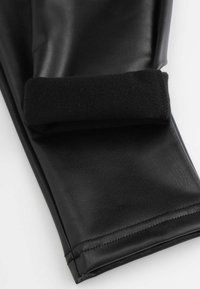 Czarne skórzane rękawice mają gładką teksturę, z miękkim, czarnym mankietem z polaru dla dodatkowego komfortu. Widoczne są stębnowane detale wzdłuż krawędzi.