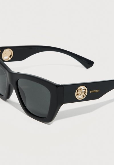 Μαύρα ορθογώνια γυαλιά ηλίου με σκούρους φακούς και χρυσά στρογγυλά διακοσμητικά με το λογότυπο Burberry στις πλαινές πλευρές, τοποθετημένα σε λευκό φόντο.