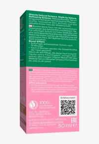 Zielon i różowy kartonik Weleda Booster Serum Drops z tekstem o pielęgnacji skóry przeciwutleniającej w języku niemieckim i francuskim, z kodem QR i objętością 30 ml.