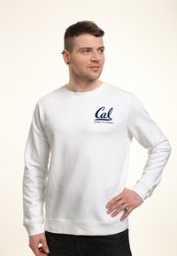 Felpa bianca con polsini e orlo a coste, con logo blu navy "Cal University of California" sul lato sinistro del petto.
