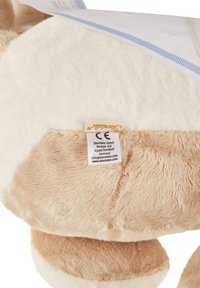 Plush teddy bear with soft, beige and cream fur, featuring a stitched label on its underside. Round shape with no visible patterns or accents.