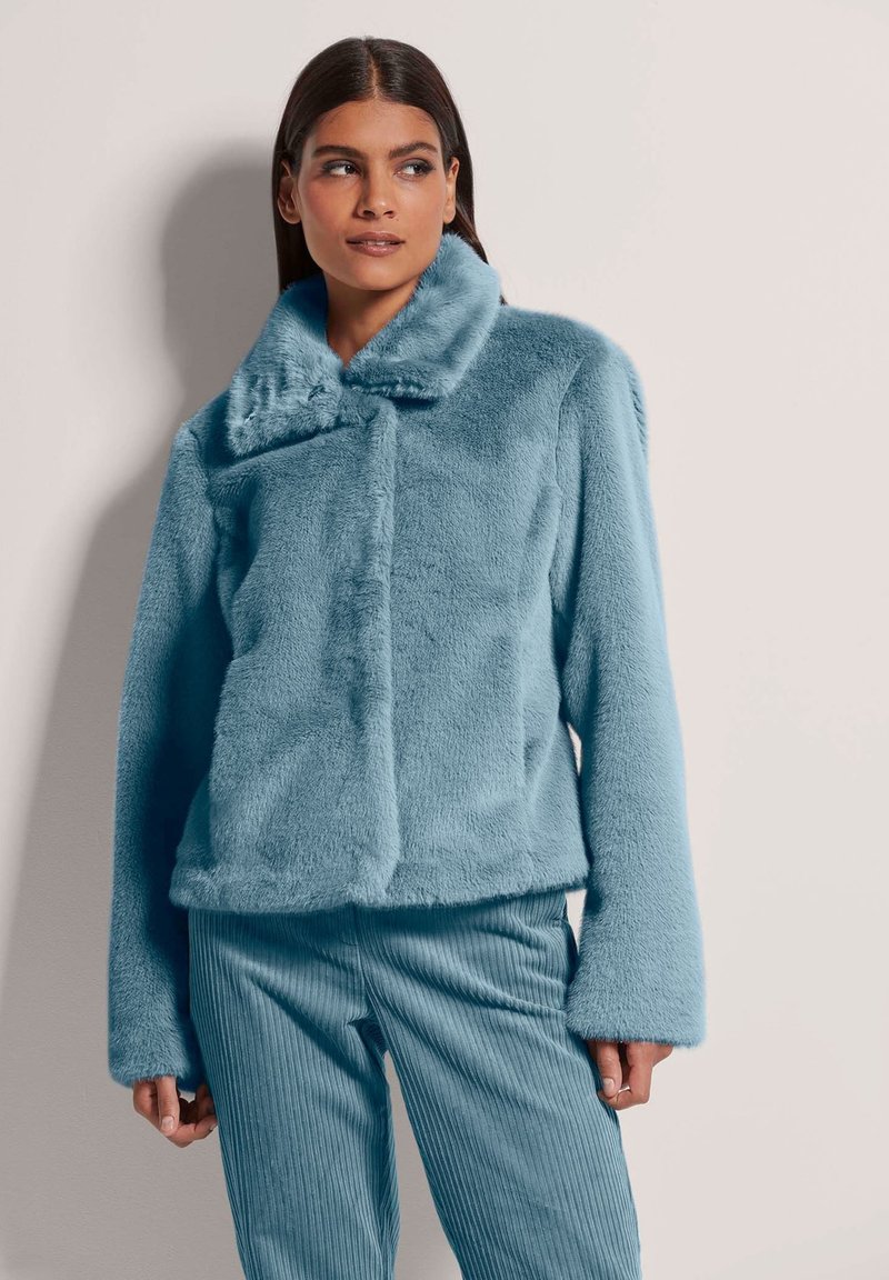 Helleblaue Kunstfelljacke mit breitem Kragen und Knopfverschluss. Das Design verfügt über lange Ärmeln und eine lockere Passform. Strukturierter Stoff in der gesamten Jacke.