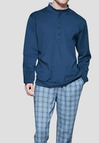 Camicia a maniche lunghe blu navy con colletto abbottonato, abbinata a pantaloni da pigiama a quadri blu e bianchi. Tessuto morbido con vestibilità rilassata.