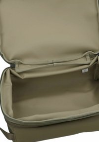 Bolso caqui con exterior suave y flexible. Forma rectangular con cierre de cremallera y un interior espacioso y sin forro. Diseño minimalista.
