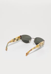 Ochelari de soare cu lentile gri închise, ramă ușoară și un model de broască țestoasă marmorat în tonuri de galben, verde și maro pe brațe.