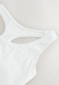 Hvid ærmeløs tanktop med rundet halsudskæring og racerback-design, lagt fladt på en lys baggrund.