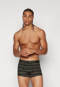 Boxers masculino em verde escuro com riscas horizontais pretas. Feitos de um tecido elástico com uma cinta elástica que apresenta o logo da Puma.