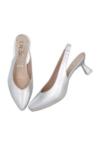 Tacones slingback plateados con punta afilada, textura de cuero suave y un tacón bajo de forma cuadrada. Incluyen una plantilla perforada para mayor transpirabilidad.