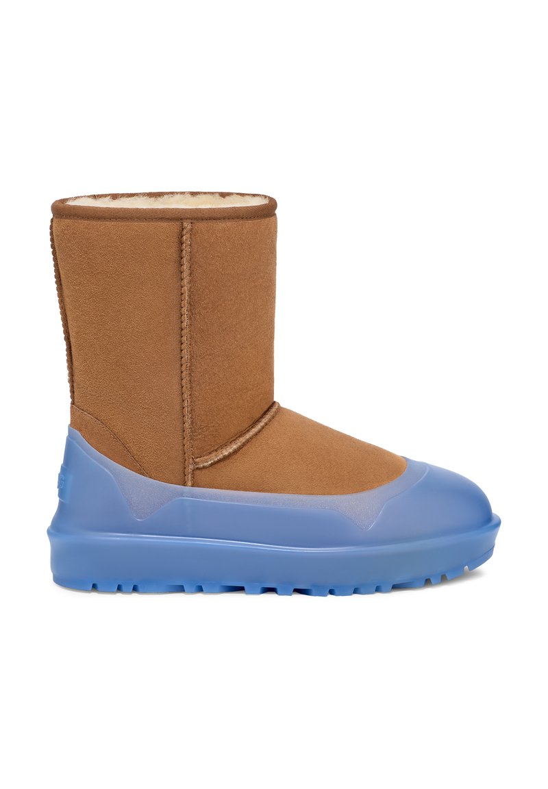 Brown suede ankle boot with a blue rubber sole. Features a soft interior lining, a rounded toe, and a stitched seam along the upper.