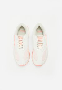 Baskets blanches avec des accents roses, dotées d'une tige en mesh, de lacets et d'une semelle arrondie. Le nom de la marque "Diesel" est visible sur la semelle intérieure.