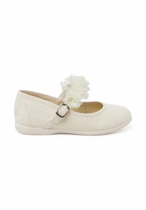 White linen ballet flats with a round toe and ankle strap, featuring a flower accent on the strap and a textured fabric finish.