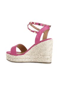Roze su�ède wedge sandalen met een gevlochten jute platform. Voorzien van enkelbandjes versierd met gouden studs en een open teenontwerp.