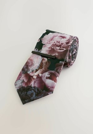 Blommig slips med en mörkgrön bakgrund och rosa samt lila pioner, slät textur och en elegant rullad design som är säkrad med en slipsögla.