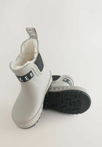 Grijze waterdichte enkellaarzen met zwarte accenten, voorzien van een zachte binnenvoering, een lus voor eenvoudig aantrekken en een getextureerde zwarte zool.