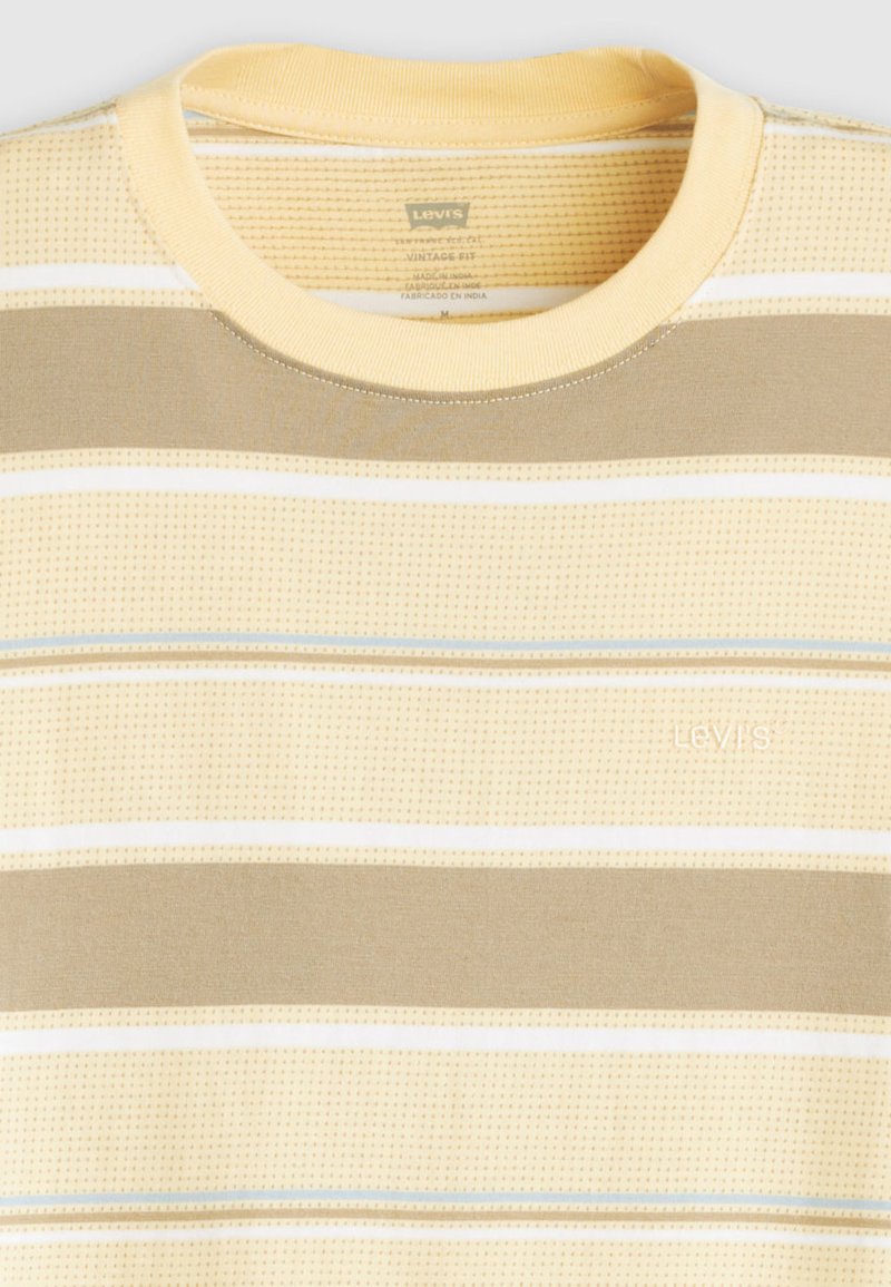 T-shirt à manches courtes et col rond avec des rayures horizontales beige, blanches et bleu clair, présentant le logo Levi's brodé sur la poitrine.
