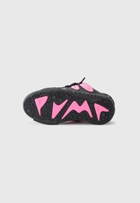 Czarne sneaki z różowymi akcentami, z teksturowaną gumową podeszwą i charakterystycznym logo PUMA na spodzie. Zapięcie na sznurówki.