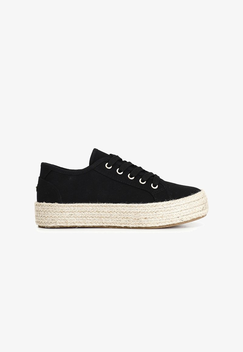 Zapatilla de lona negra con punta redonda, suela de goma y mediado de esparto tipo yute natural. Cuenta con seis ojales y cordones negros.