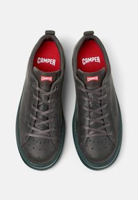 Dark gray leather sneakers with perforated detailing, featuring red "Camper" logos on the interior and tongue, displayed from above.