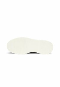 Valkoinen kuminen kengänpohja, jossa on tekstuuripinta ja kohokuvioitu brändäys, tasaisena valkoista taustaa vasten.