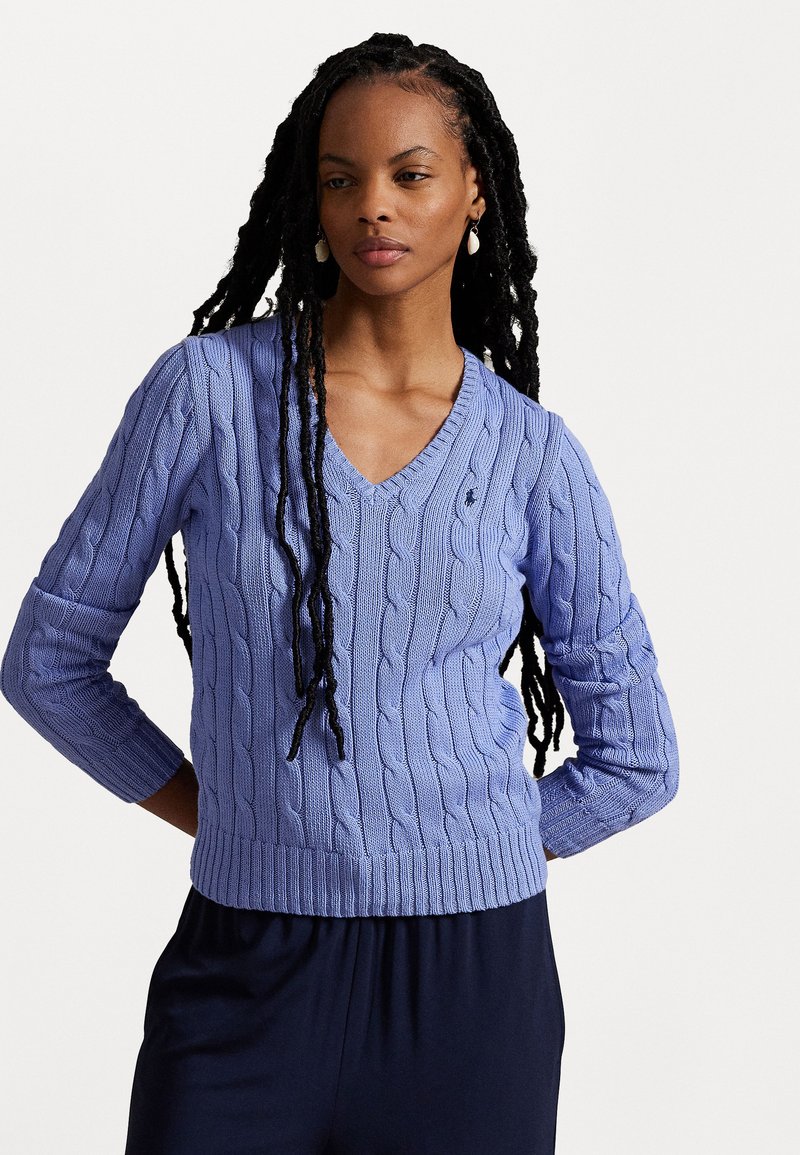 Light purple cable-knit sweater with a V-neck, ribbed hem, and three-quarter sleeves. Features textured pattern and small logo detail.