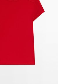 Red short-sleeve shirt with round neckline, shown from front, cropped at the left side, against a white background.
