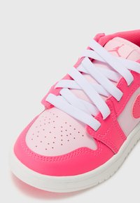 Różowe sneakersy z gładkiej skóry i siateczki, białe sznurówki, perforowane czubki oraz kontrastująca biała podeszwa.