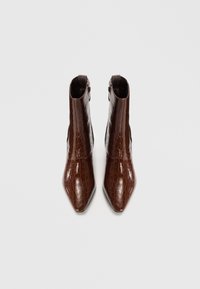 Botas de tobillo de imitación de cocodrilo de color marrón con punta afilada y acabado brillante. Cuenta con una cremallera lateral y un diseño ajustado en el tobillo.