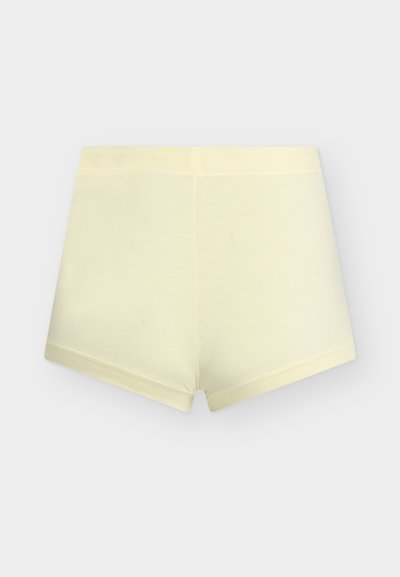 Ανοιχτό κίτρινο ελαστικό χωρίς ραφές ανδρικό μποξεράκι, απλωμένο επίπεδα σε λευκό φόντο.