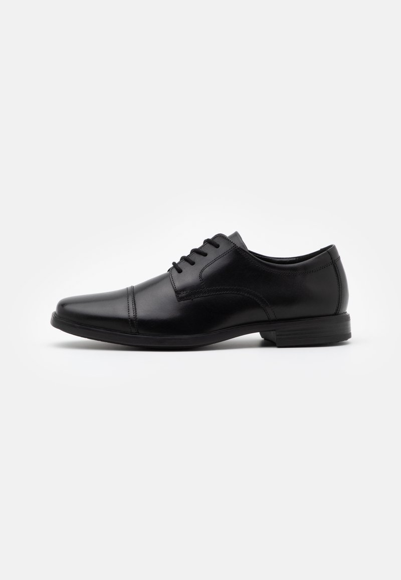 Pantofii de piele negri, cu vârf ascuțit, design cu șireturi, detalii fine de cusătură și o talpă din cauciuc texturată, joasă.