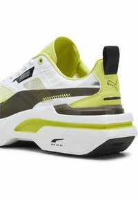Sneakers bianche e giallo neon con tacco traslucido, parte superiore in mesh testurizzato e dettagli neri. Caratterizzati da un collare imbottito e suola in gomma.