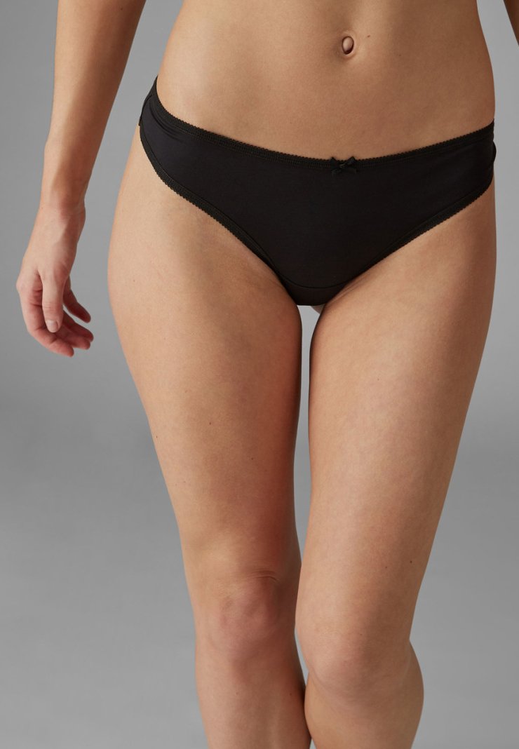 Zwarte katoenen bikini slipjes met een gladde textuur, voorzien van een delicaat strikaccent aan de voorkant en een golvende tailleband.