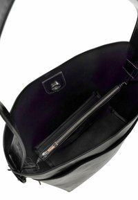 Black leather handbag with a smooth exterior, featuring a sleek design, interior zip pocket, and dark fabric lining.