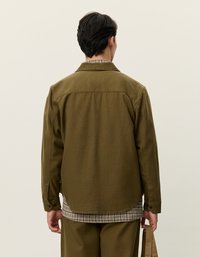 Λαδί πράσινο σακάκι πουκάμισου με γιακά που κουμπώνει, κατασκευασμένο από υφασμάτινη ύλη με υφή, με ζώνη και διπλές πτυχές στην πλάτη για επιπλέον κίνηση.