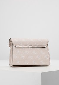 Kompaktowa beżowa skórzana kopertówka z tłoczonym powtarzającym się wzorem logo i klapką, umieszczona na białym postumencie na szarym tle.