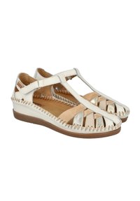 Las sandalias blancas y doradas presentan un diseño de tirante en T, punta abierta y detalles de cuero trenzado en los bordes. Suelas de goma ligeras y flexibles.