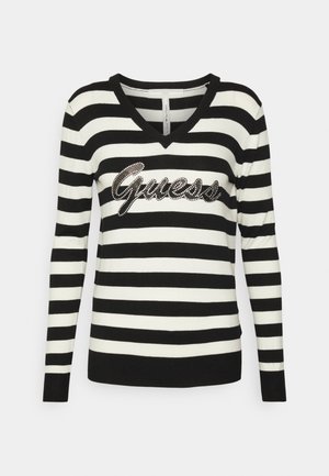Pull rayé noir et blanc avec un col en V, orné d'un logo "Guess" en strass à l'avant. Manches longues et poignets côtelés.