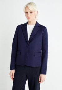 Blazer sartoriale navy in tessuto elasticizzato, presenta una chiusura con un bottone, due tasche frontali, rever a falda e un design slim fit.