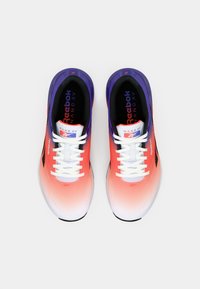 Reebok Nano XV sporta apavi ir koralju un baltu toņu gradients, purpura akcenti, elpojoša augšdaļa un balti šņores.