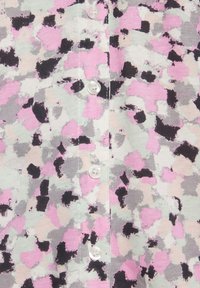 Strickjacke mit einem gepunkteten Muster in Rosa, Grau und Schwarz. Verfügt über vier weiße Knöpfe auf der Vorderseite. Weiche Textur.