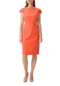 Robe ajustée en corail avec des manches courtes, silhouette midi et texture lisse. Assortie à des talons hauts nude. Design épuré et minimaliste.