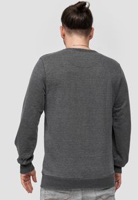 Grauer Sweatshirt, lange Ärmel, gerippte Bündchen und Saum, aus einem strukturierten Stoff hergestellt. Verfügt über einen runden Ausschnitt und ein schlichtes Rückendesign.
