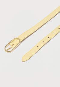 Ceinture en cuir jaune avec une boucle ovale dorée. La sangle présente des trous régulièrement espacés pour les réglages et une texture lisse.
