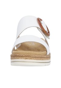 White leather sandal with a wide strap and a round brown buckle, featuring a cushioned insole and a textured sole with braided accents.