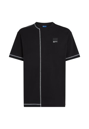 T-shirt noir à manches courtes en coton avec des coutures blanches contrastantes et un patch logo carré sur la poitrine. Coupe décontractée, régulière.