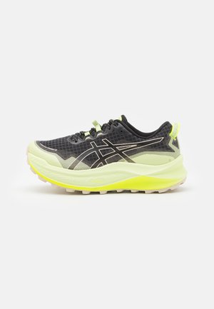 Chaussure de sport noire et vert néon avec tige en mesh respirant, détails à motif et semelle texturée pour la traction. Fermeture à lacets.