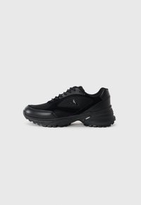 Black athletic shoes with mesh and synthetic materials, textured surfaces, padded collar, lacing system, and a chunky rubber sole.